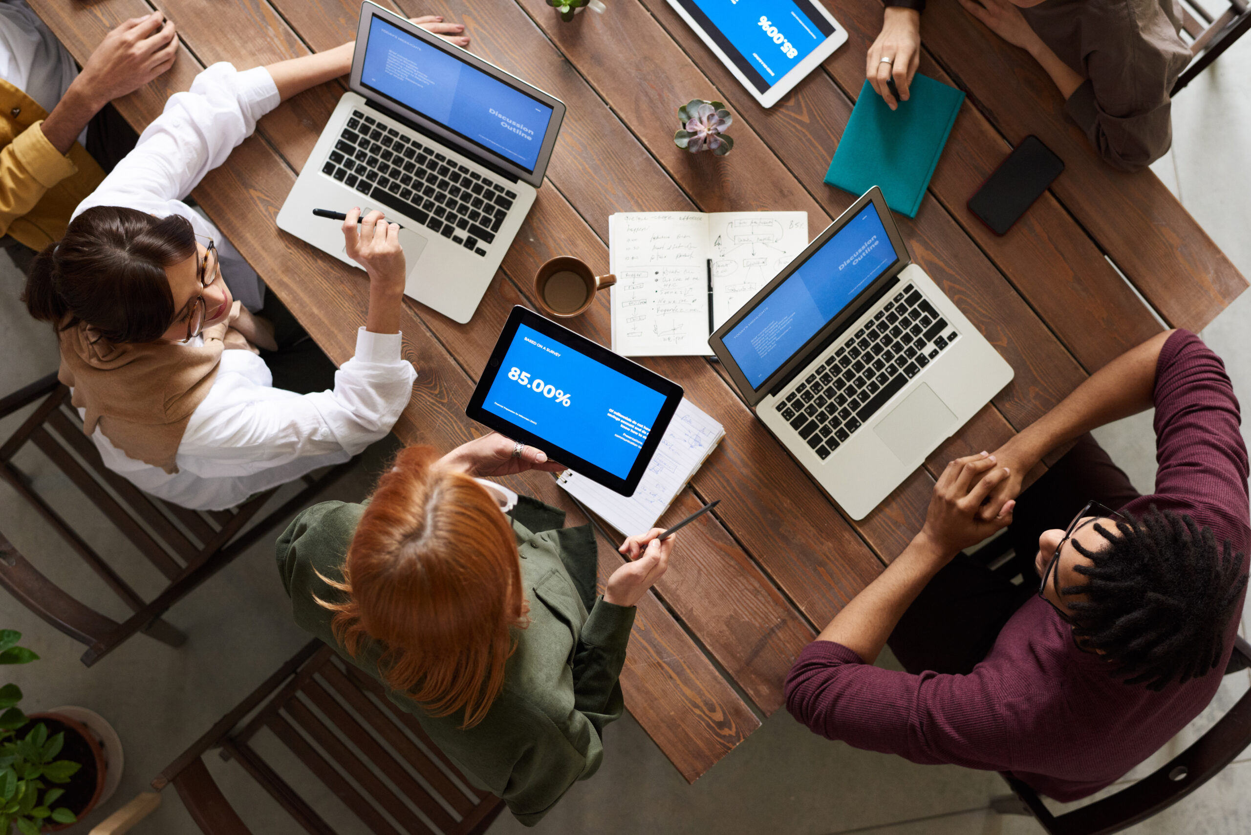 top-view-photo-of-group-of-people-using-macbook-while-3182773